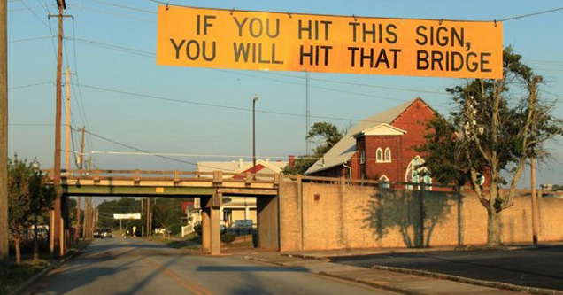 overpass with a sign in front of it that says: If you hit this sign, you will hit that bridge.