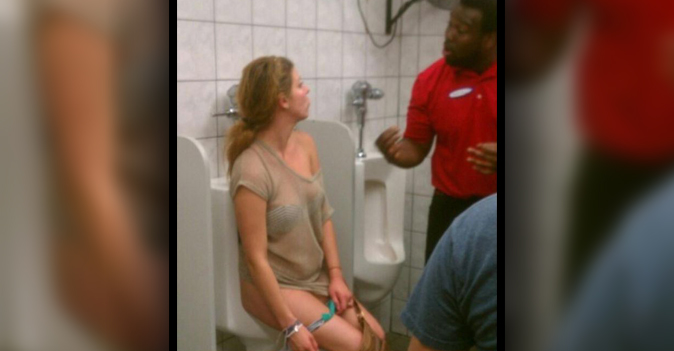 employee talks to indignant woman sitting in a urinal.