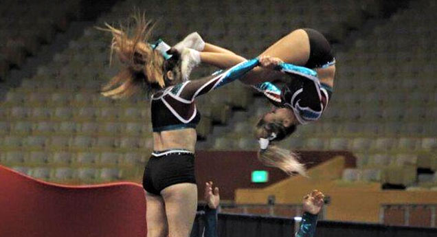 cheerleader doing a flip and kicking another cheerleader in the face