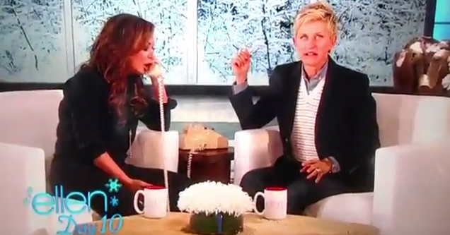 leah remini using a phone while sitting together on a couch with ellen degeneres both of them looking outraged