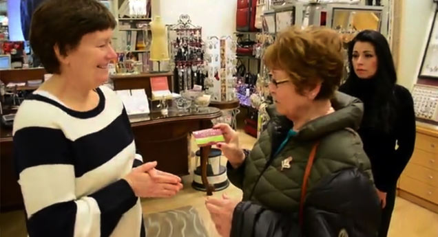 short haired woman giving a card to another woman