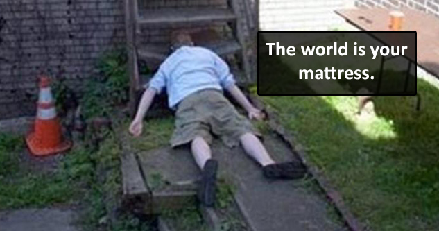 Guy sleeping on the ground with his face on the bottom stair. Caption reads: The world is your mattress.