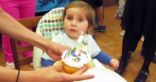 surprised boy with birthday cupcake