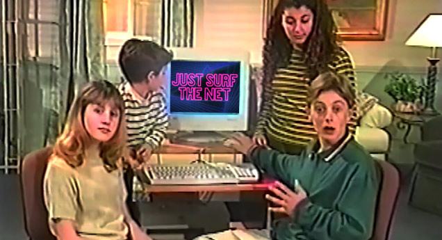 kids sitting around computer that says just surf the net