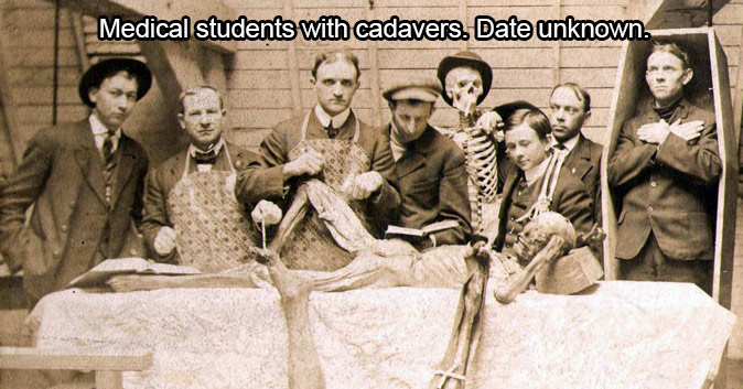 Sepia tone picture of men in suits standing around corpses. Text: Medical students with cadavers. Date unknown.