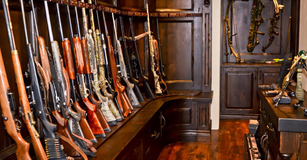 A room that is full of guns and bows.