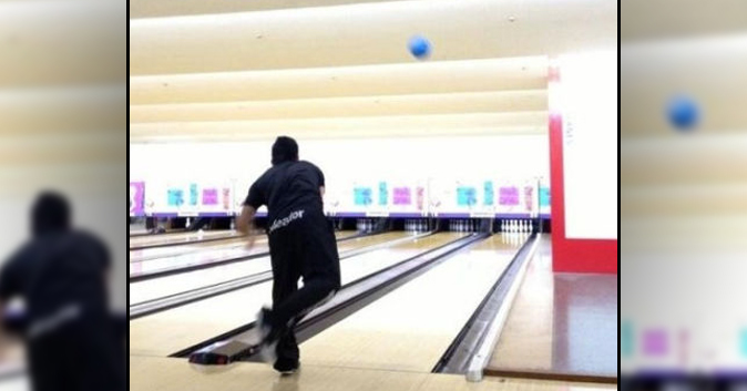 Guy throws a bowling ball.