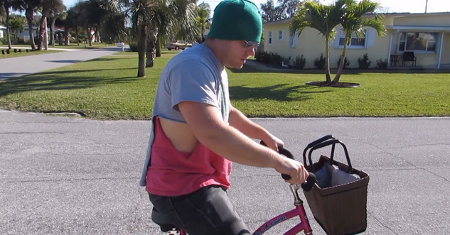 Creepy guy sits on bike and doesn't look at camera.