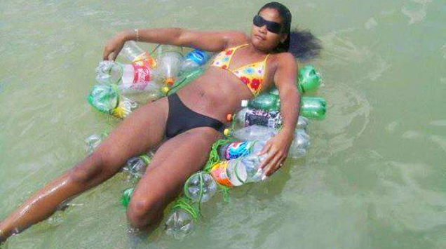 girl in bikini floating on empty plastic bottles