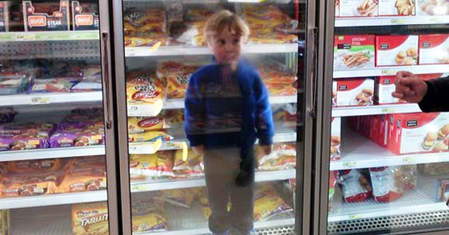 kid in the refrigerator at supermarket