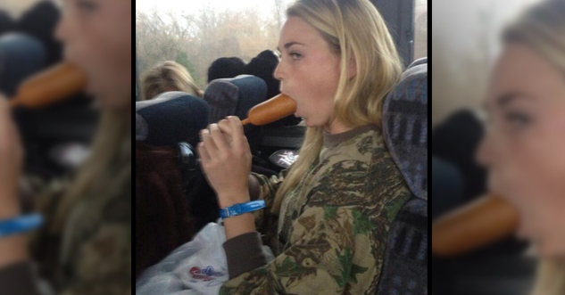 Hot woman eating a corn dog in public.