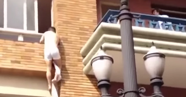 Husband looks pissed on a balcony while guy in his underwear climbs down a rope made of bed sheets.