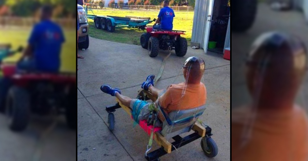 guy strapped to a chair on wheels, which is in turn attached to a dune buggy.