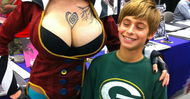 Kid smiles at boobs of a cosplayer at a convention.