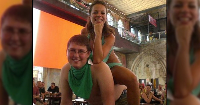 Girl in a bikini sits on a friend's back. he's smiling and looks pathetic.