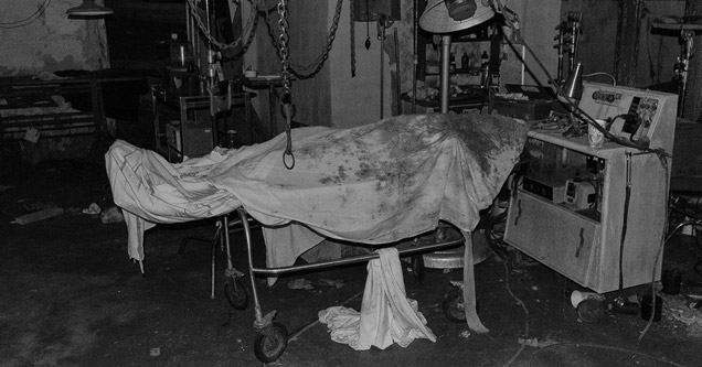 bed covered in dirty sheet in an abandoned hospital