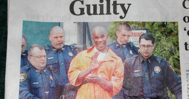 prisoner standing with policemen smiling and waving at camera