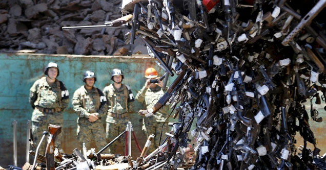 Confiscated weapons hang from a magnet before being destroyed at a foundry in Santiago, Chile.