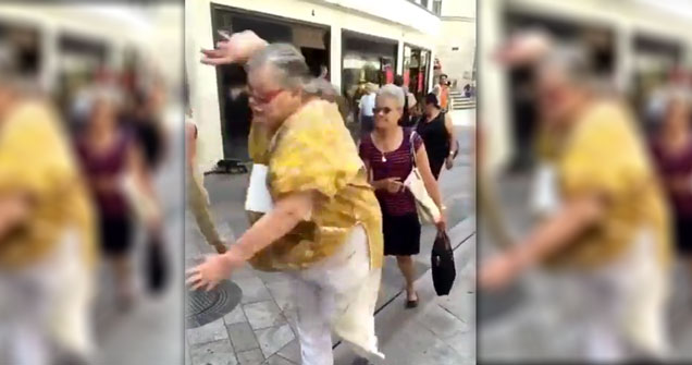 elderly woman falling on a crowded sidewalk