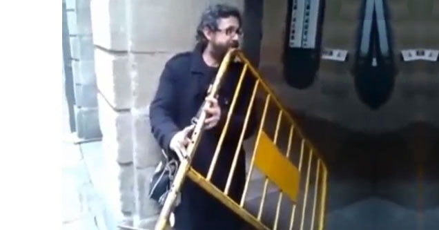 man holding barrier and playing it like a flute