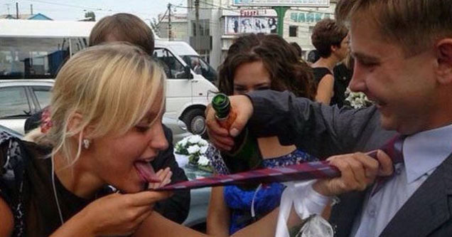 woman taking shot from man's tie