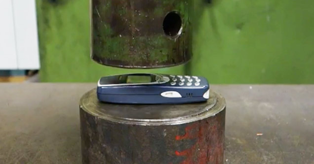 Nokia 3310 about to be smashed by a hydraulic press