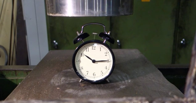 Alarm clock getting crushed by an hydraulic press