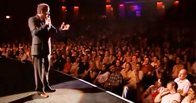 suited man on stage in front of audience