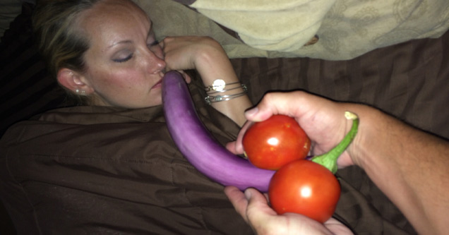 sleeping woman with an eggplant and two tomatoes held to her face