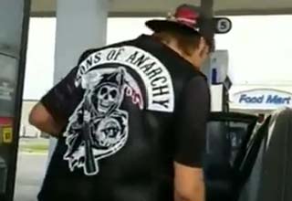 guy wearing SOA vest while getting gas
