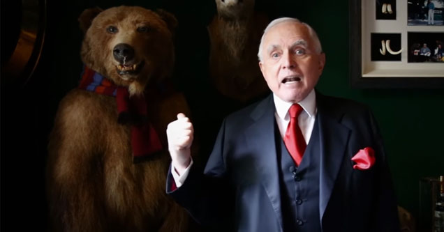 man in suit and red tie pointing at a bear