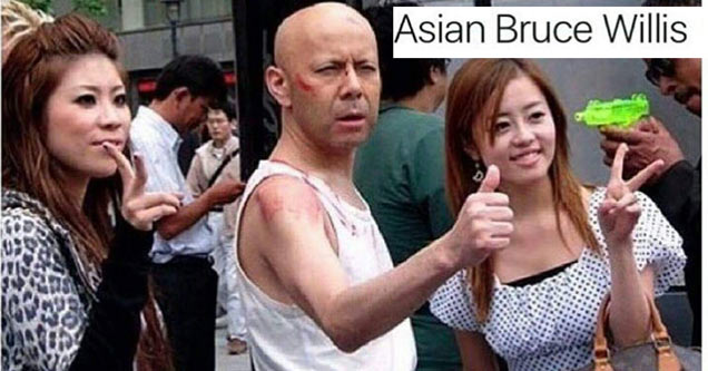 bald asian man who looks like bruce willis posing between girls