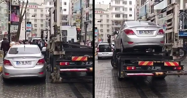 car on ground being hoisted onto tow truck