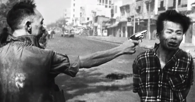 a Vietnamese man holding a gun at a prisoner