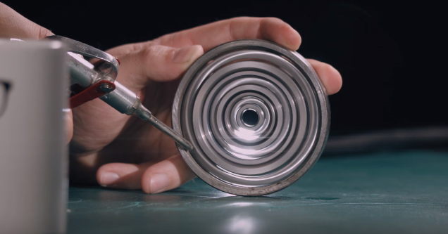 man holding a ball bearing spinner he built