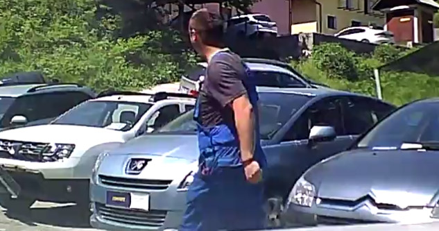 car lot employee walking by looking at cars