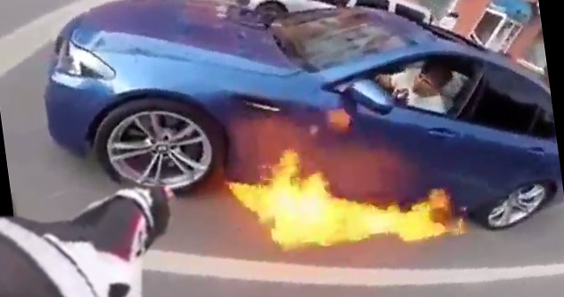 biker pointing at car on fire