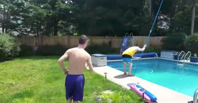 shirtless kid sneaking up on his dad cleaning the pool