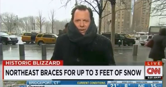 a cnn weatherman standing out in the snow looking cold and sad