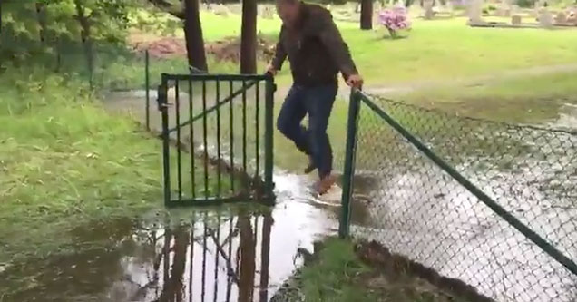 cowboy hanging on a fence trying to keep his boots dry