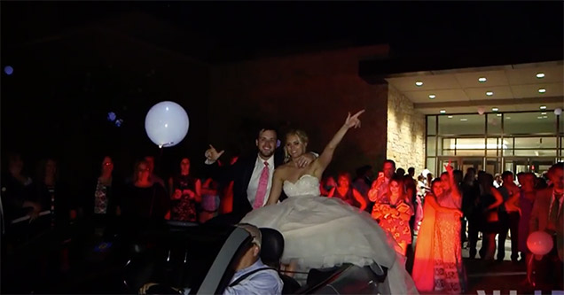 Bride and Groom sitting at the back of a convertible, about to fall off backwards