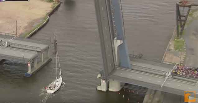 sailboat crossing stops a bike race