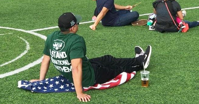 jets fan sitting on flag - Ng Stand Utions