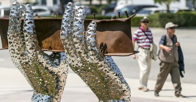 a memorial for september 11th that's a pair of shiny metal hands made of doves hold a steel beam from the twin towers