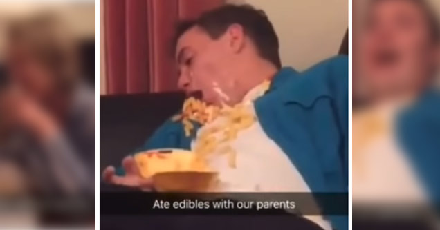 a guy wearing a blue shirt covered in nachos and cheese laughing high on edibles