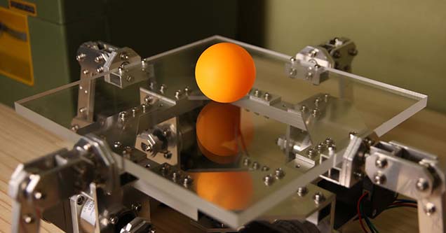 An orange ping pong ball sitting on top of an arduino powered device that perfectly bounces the ball.