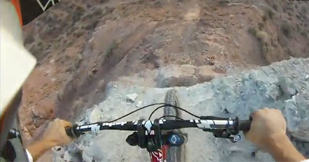 mountain biker goes down a huge canyon drop