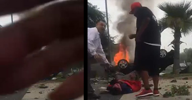 guy rescuing a man from a flipped car on fire