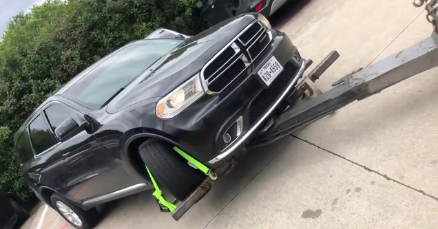 a black SUV on a repo truck