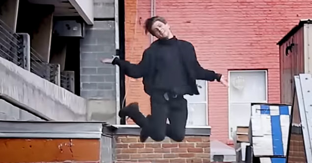 a guy jumping off a wall kicking his heels up